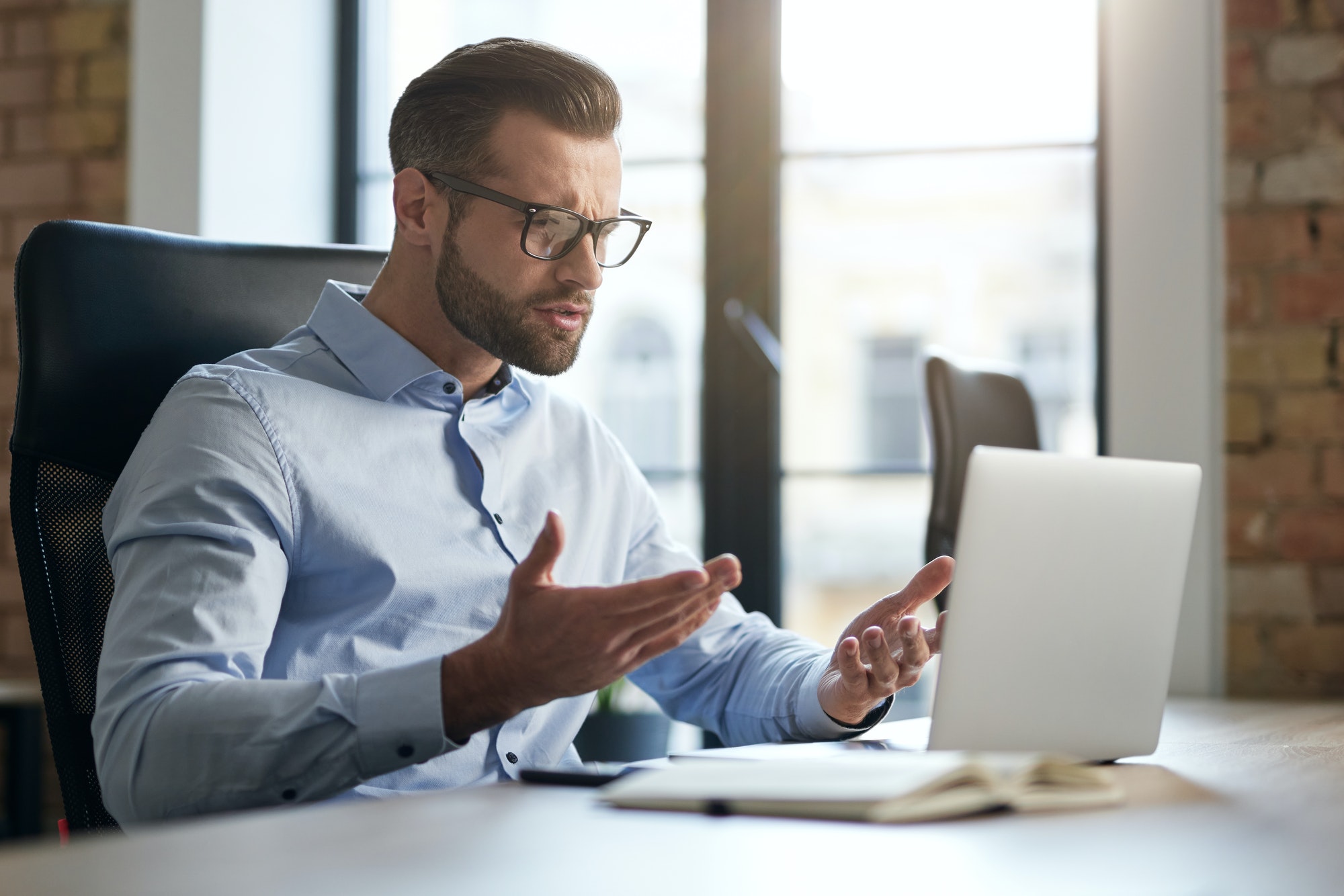 Employee looking at the screen of laptop and having questions