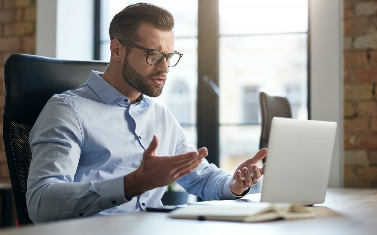 Employee looking at the screen of laptop and having questions